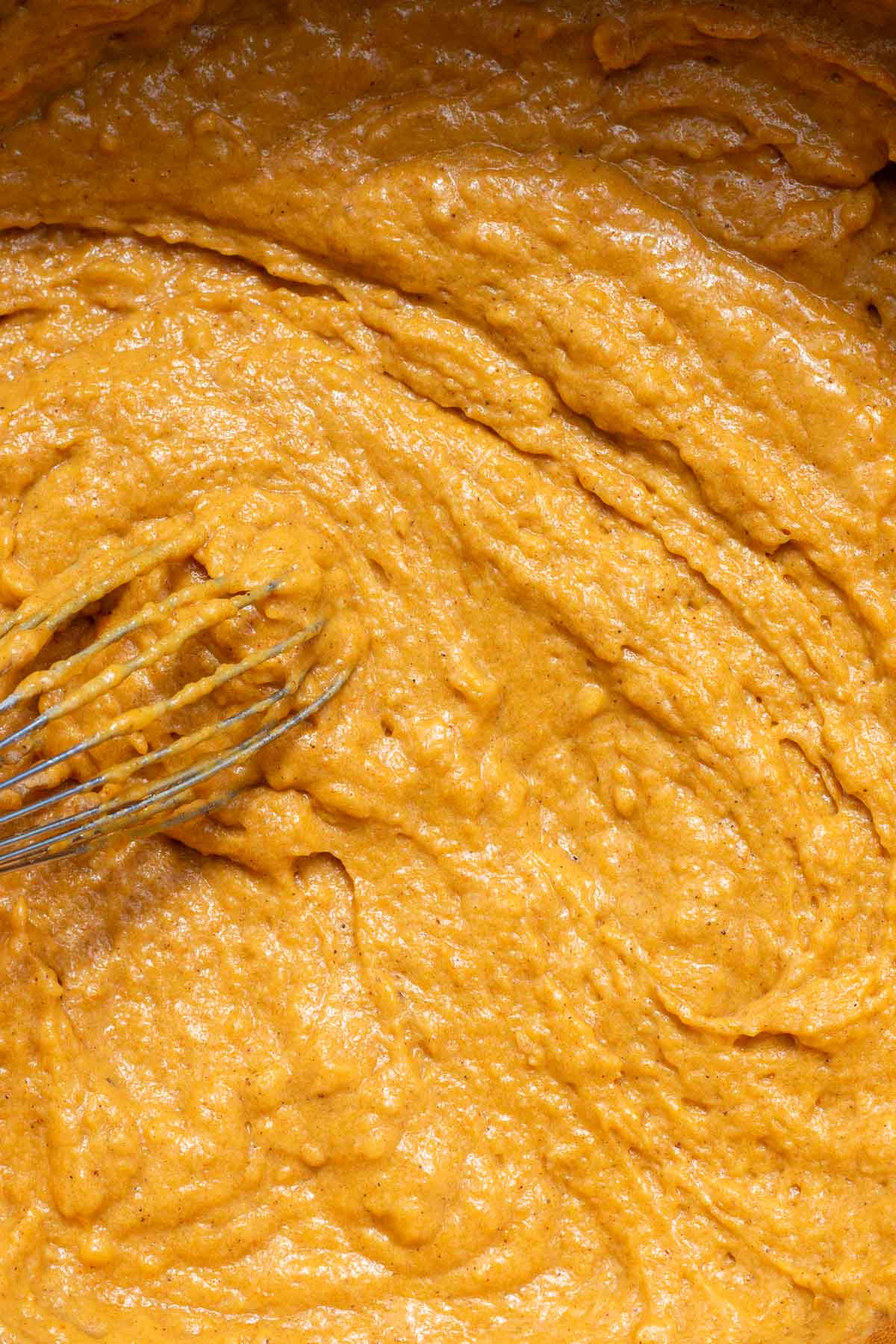 Sourdough pumpkin muffin batter in bowl with a whisk.