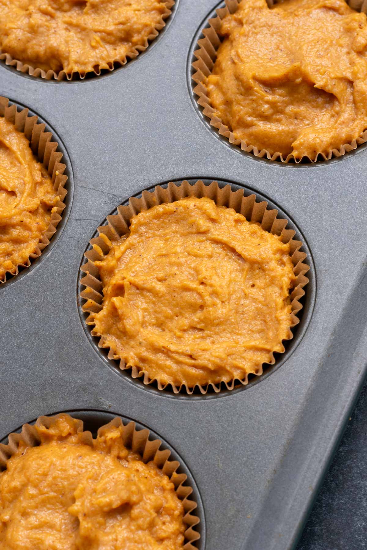 Sourdough pumpkin muffin batter in muffin tins
