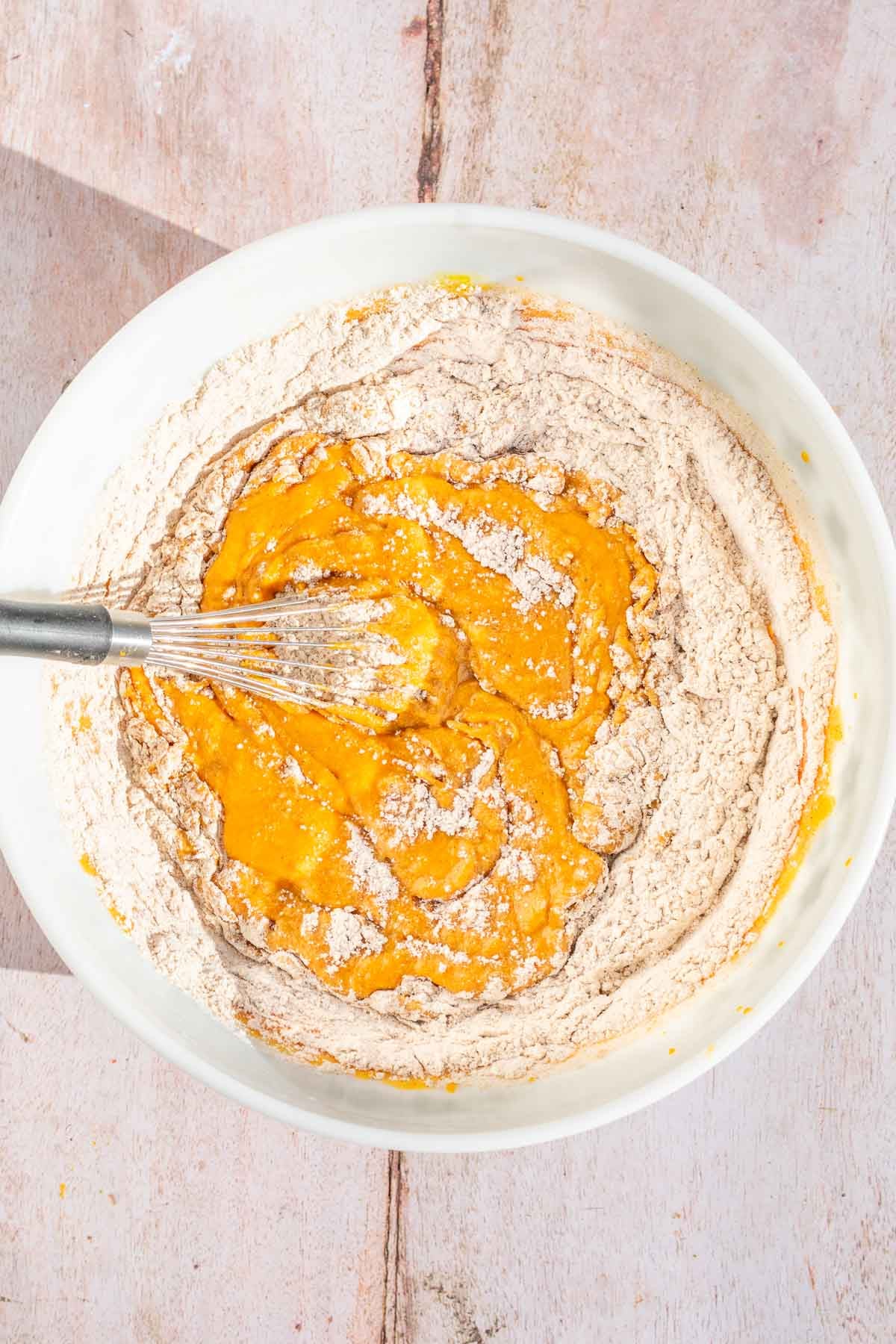 Bowl of wet and dry ingredients in a bowl not fully mixed.