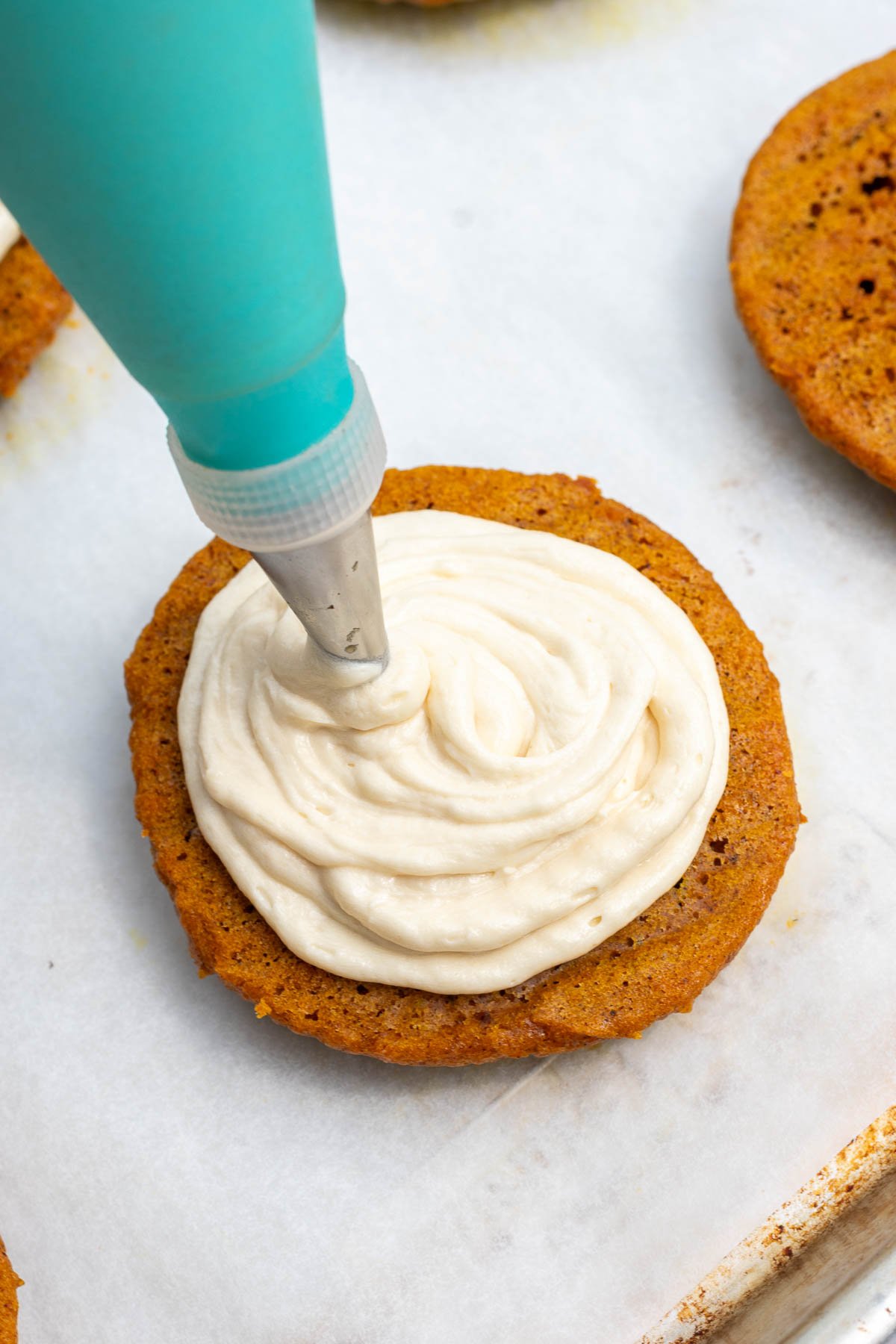 Piping salted maple buttercream to the sourdough pumpkin whoopie pies.