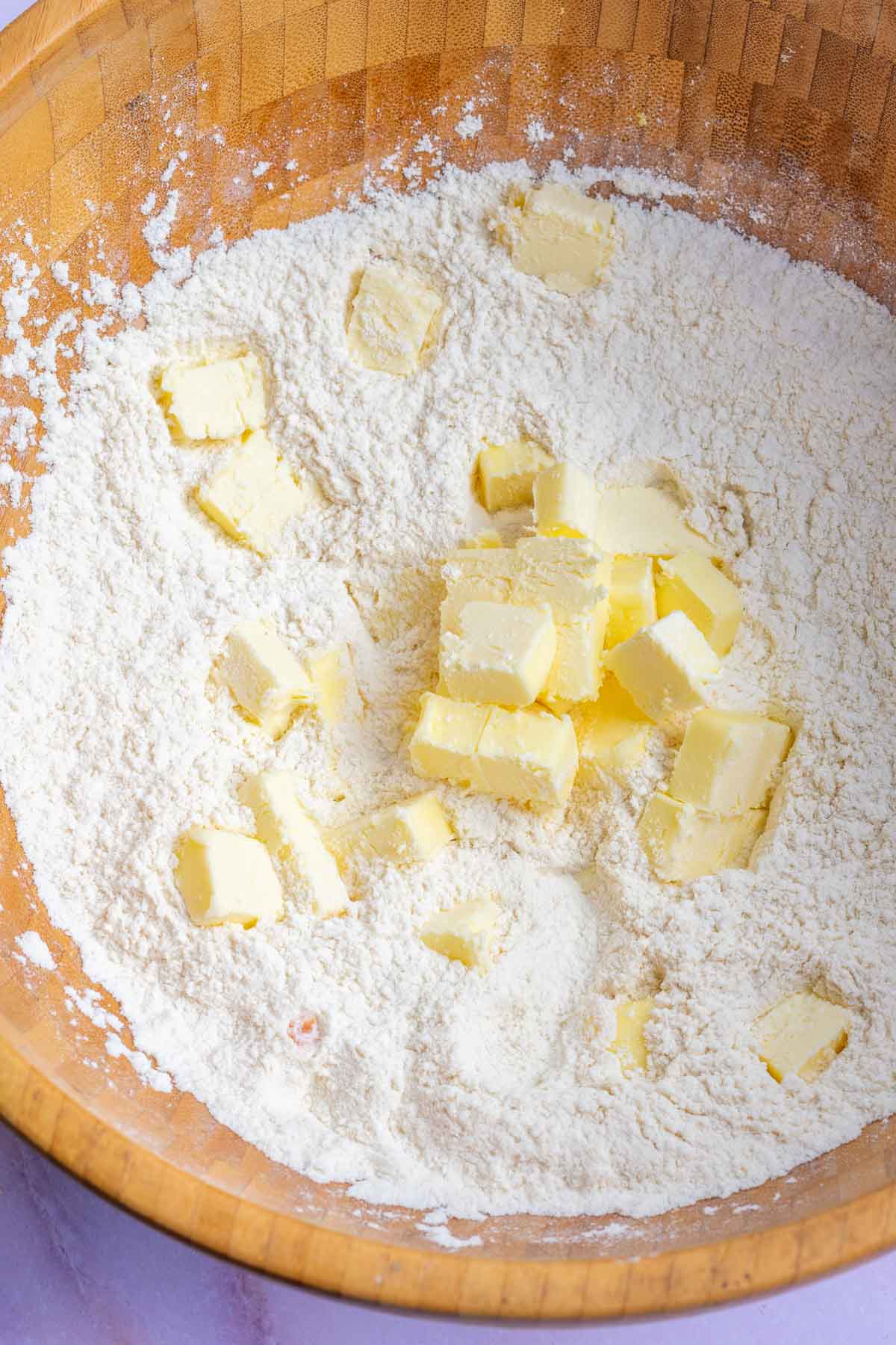 Cubed butter in bowl of dry ingredients.