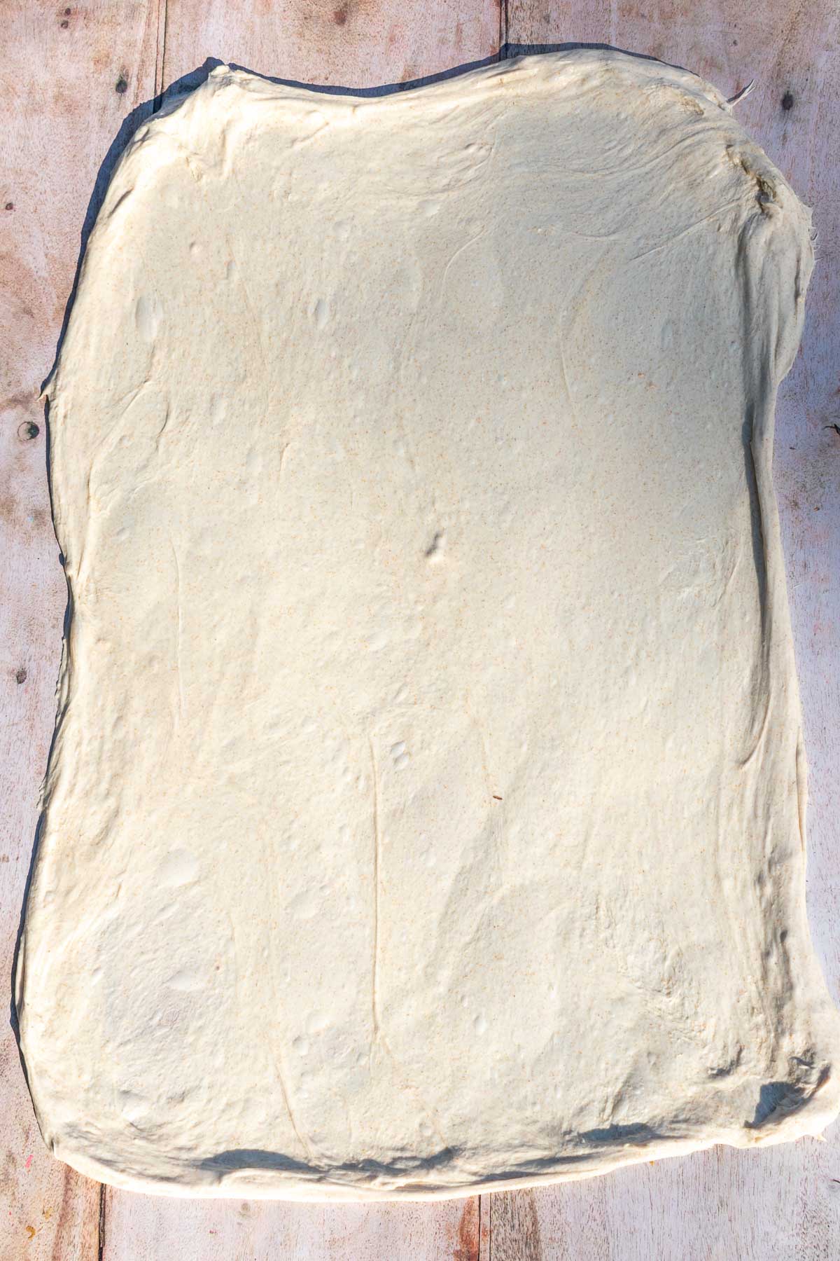 Sourdough dough stretched into a large, thin sheet for lamination.