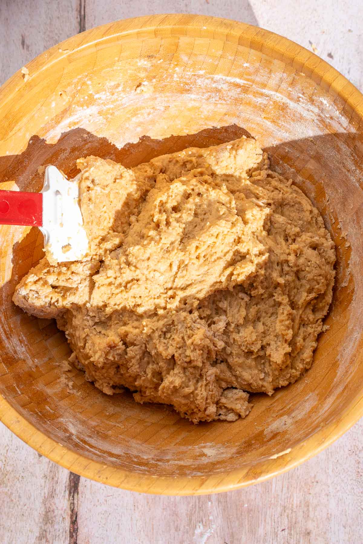 Mixed sourdough apple cider donut batter in a large bowl with a spatula.