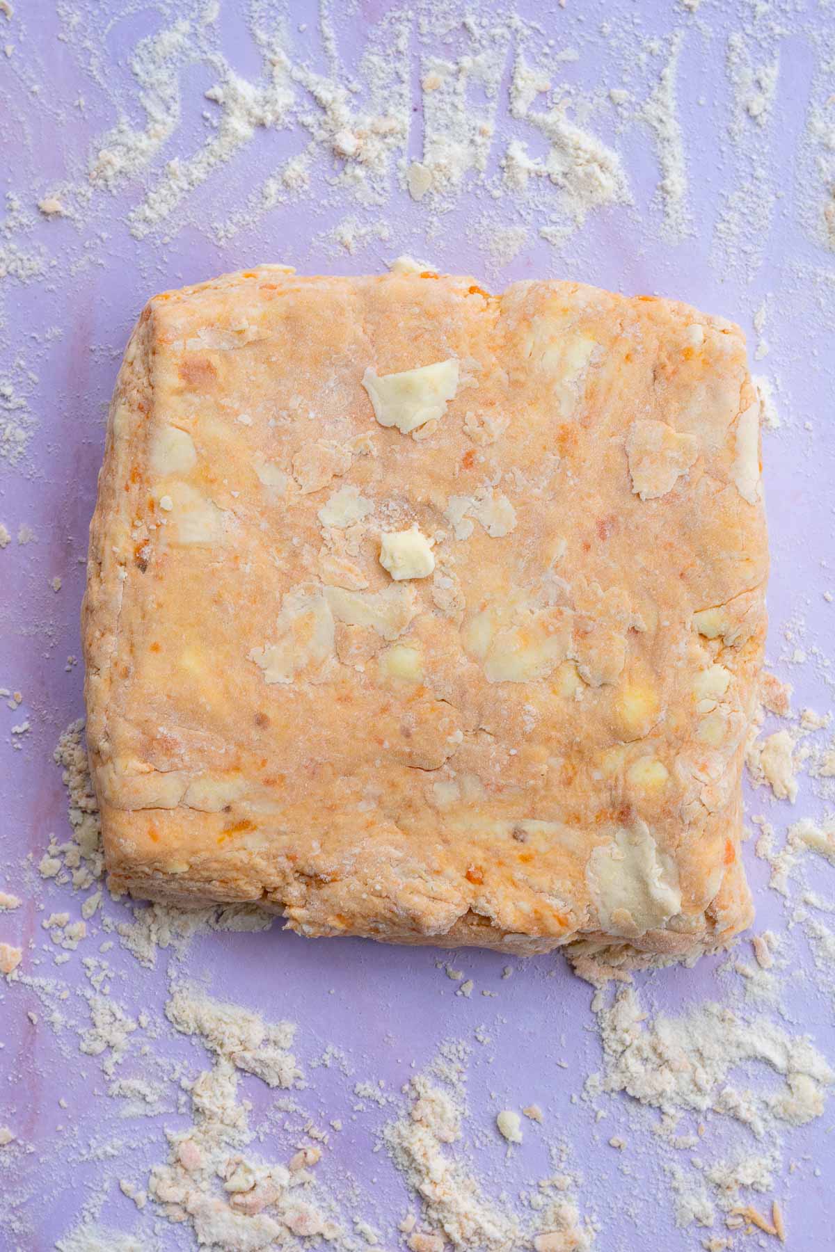 Sourdough sweet potato biscuit dough patted into a square before cutting.