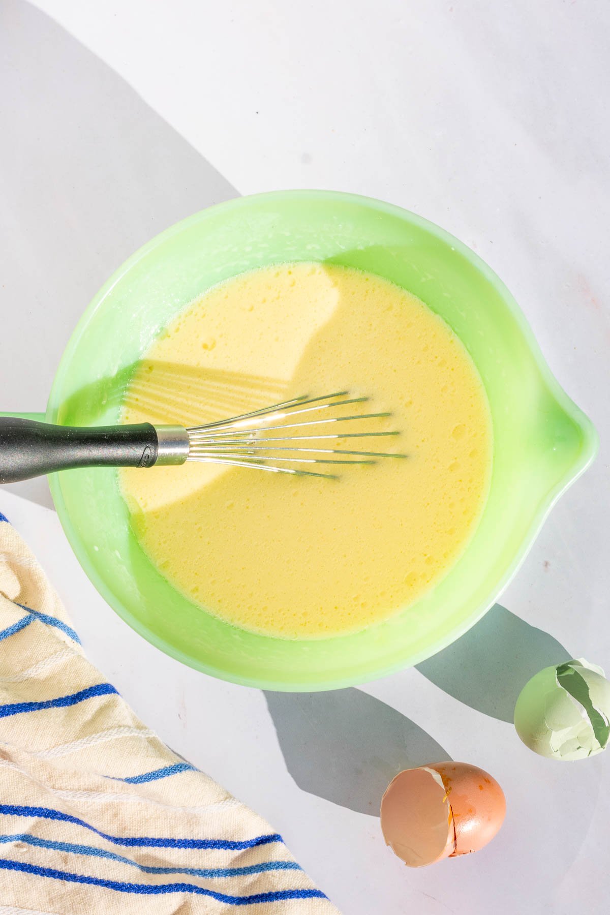 Bowl of mixed wet ingredients with a whisk.
