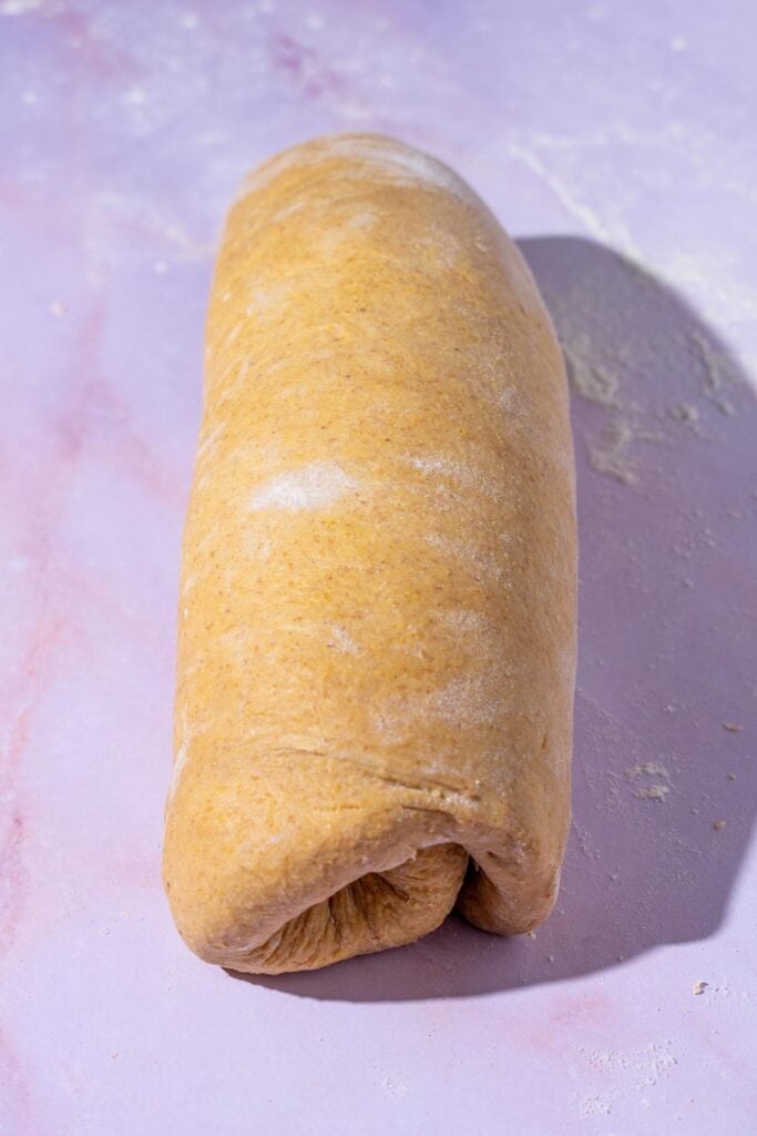 Sourdough anadama bread rolled up into a log.