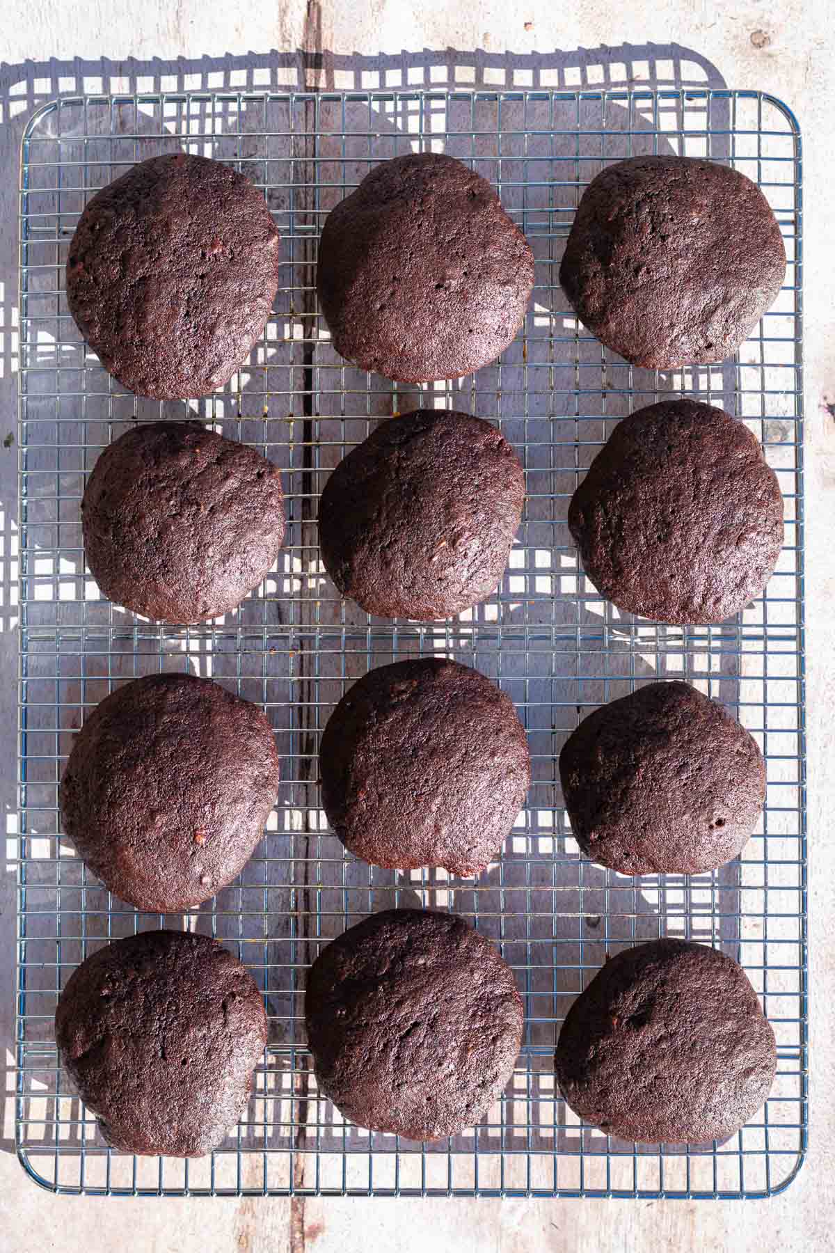 Baked sourdough chocolate peppermint whoopie pies on a wire rack.
