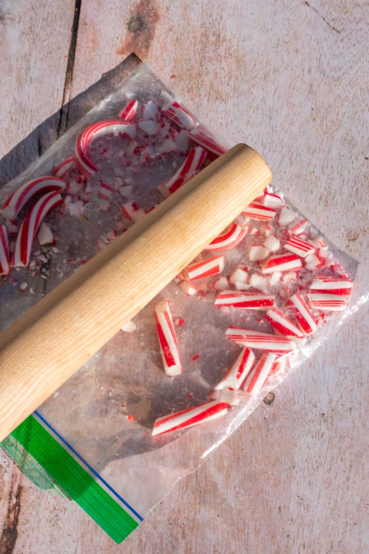 Crushing candy canes in a bag with a rolling pin.