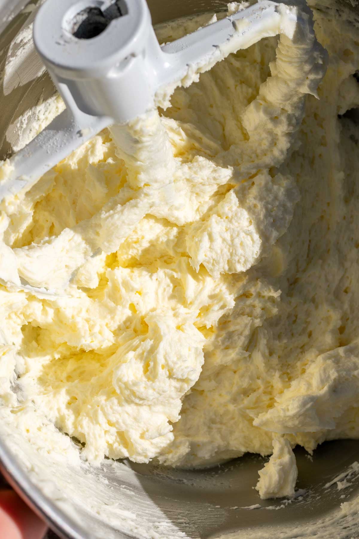 Peppermint buttercream mixed in a stand mixer bowl with the paddle attachment.