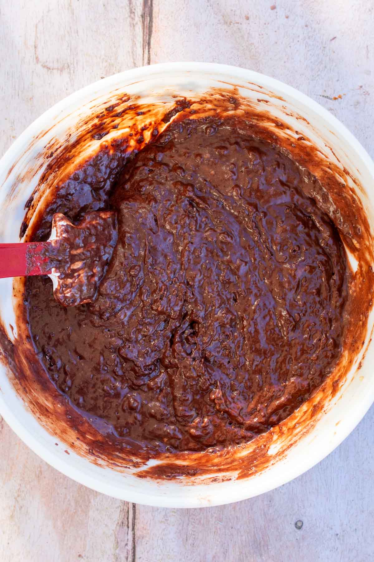 Bowl of mixed sourdough chocolate peppermint whoopie pies batter with a spatula.