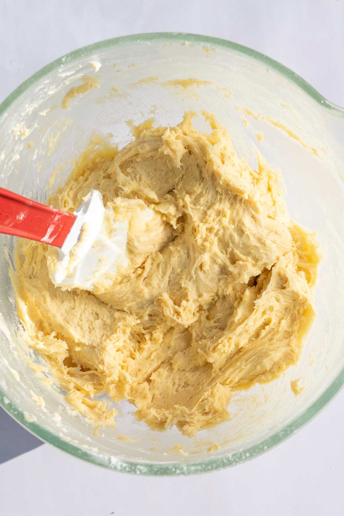 Bowl of sourdough snickerdoodle dough with a spatula.