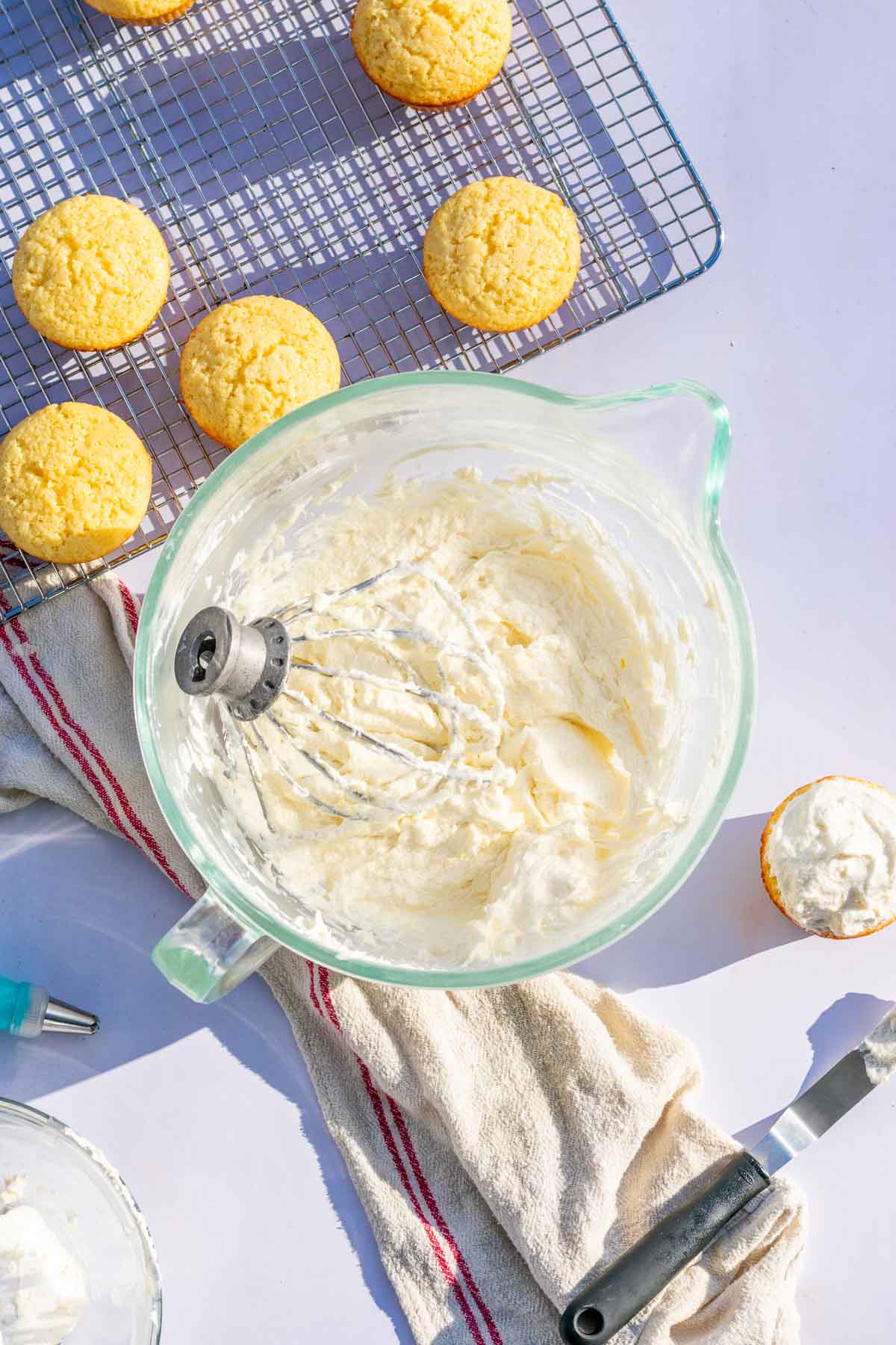 Sourdough frosting in a stand mixer bowl with a whipping attachment in the bowl.
