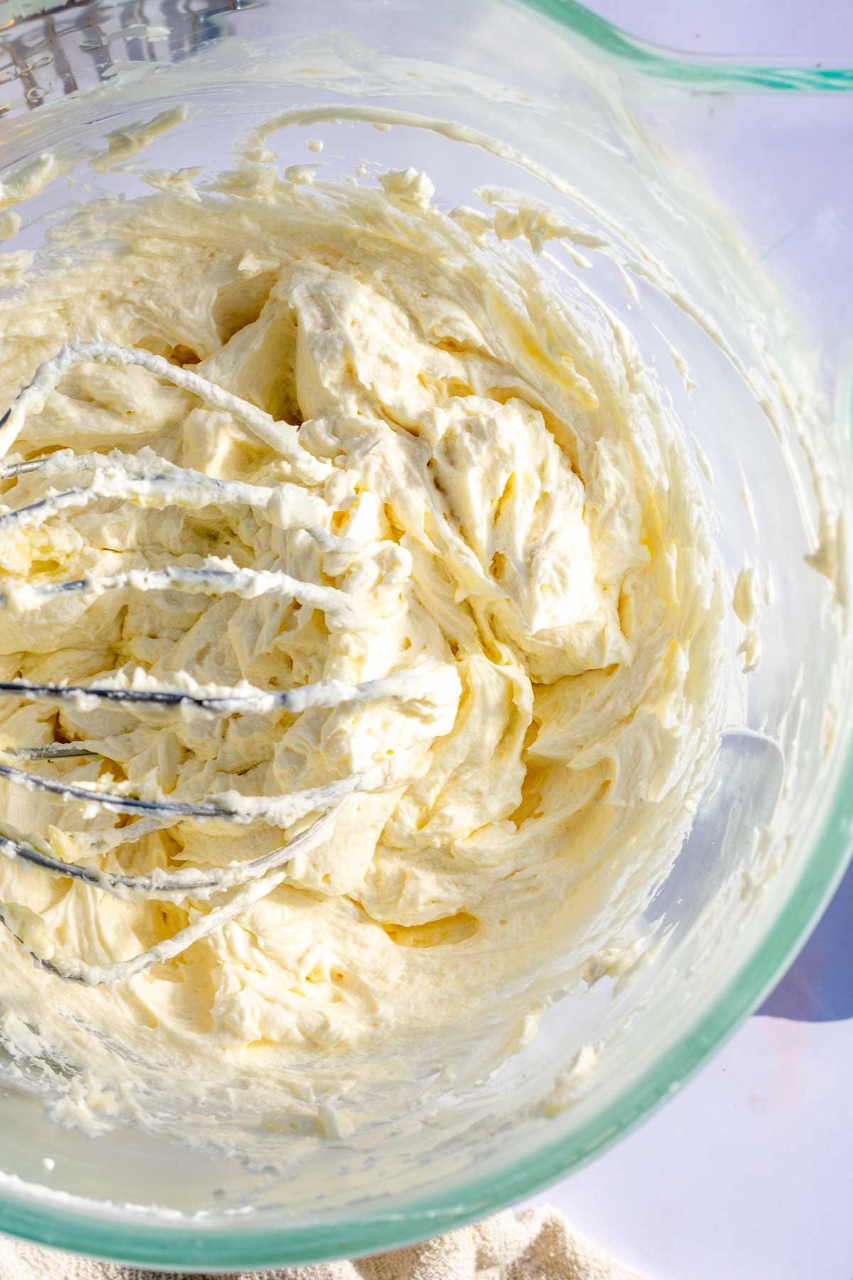 Sourdough frosting in the the bowl of a stand mixer with the whisk attachment.