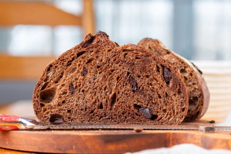 Chocolate coffee sourdough bread sliced in half on a cutting board.