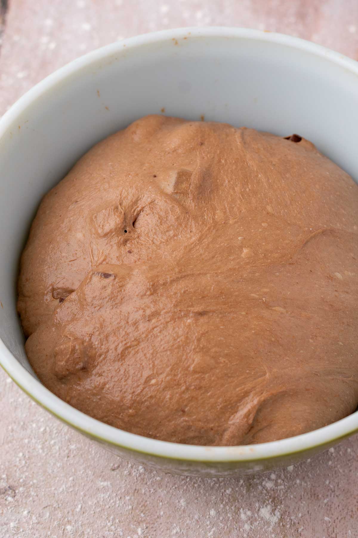 Chocolate coffee sourdough bread doubled in size at the end of bulk fermentation in bowl.
