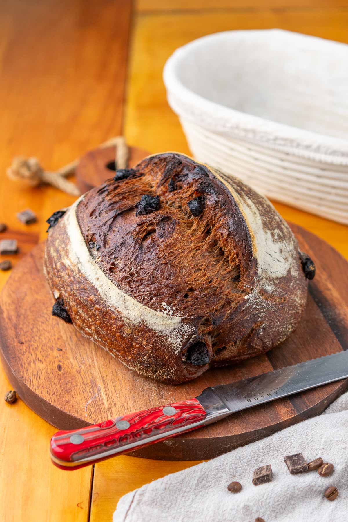 Loaf of chocolate coffee sourdough bread on a cutting board with a bread knife.