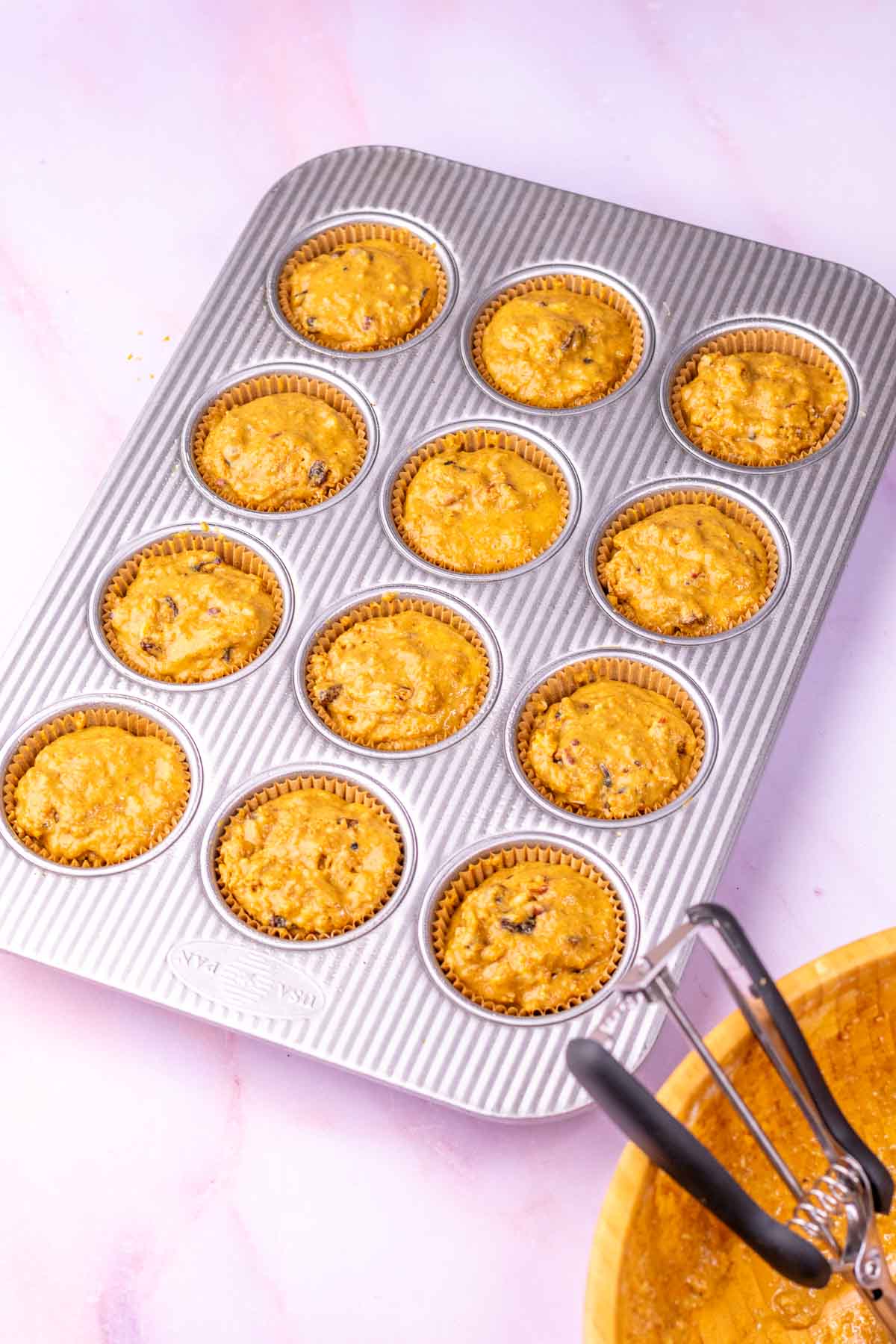 Muffin pan of unbaked sourdough bran muffins.