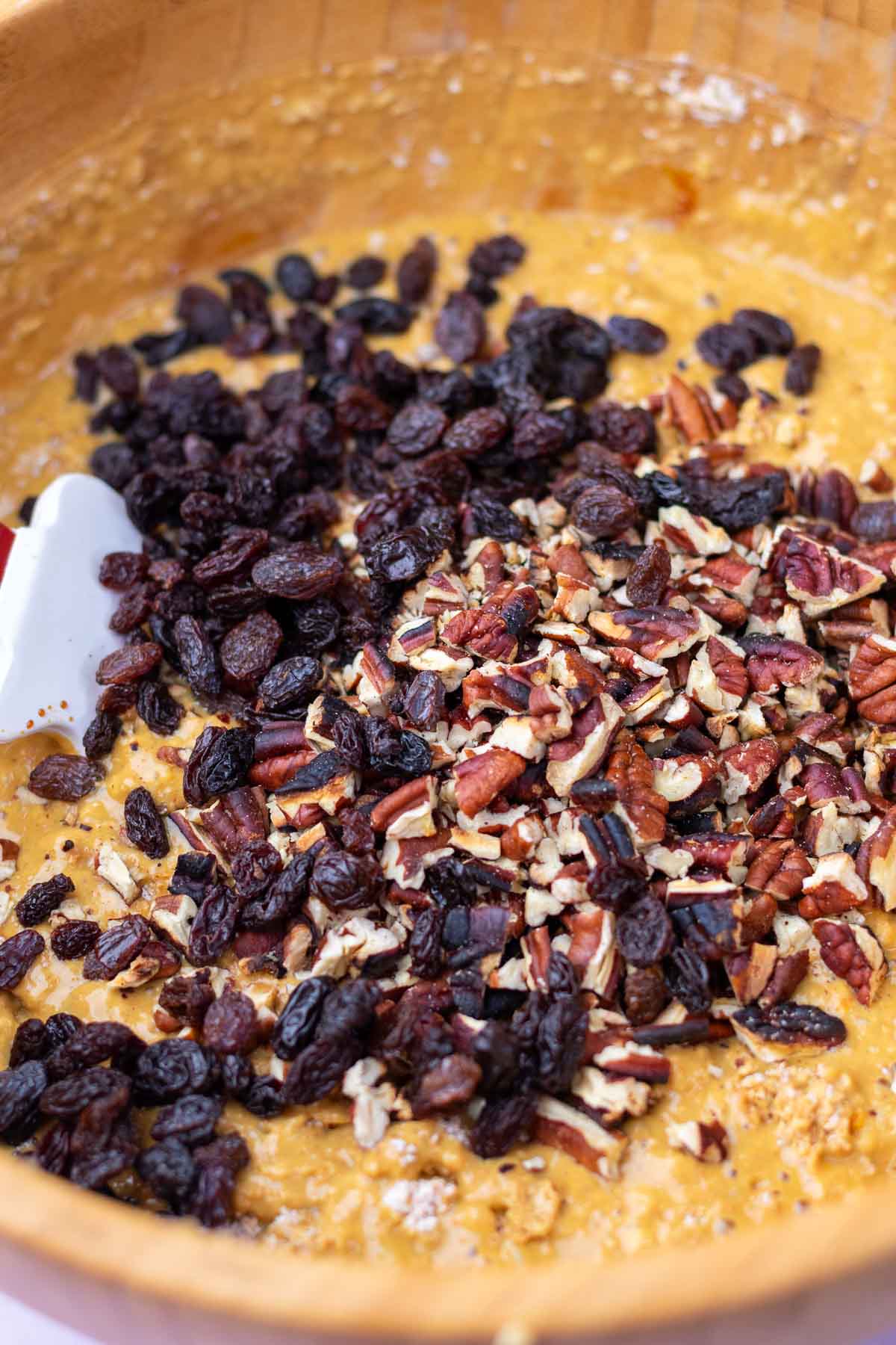 Raisins and pecans added to bowl of sourdough bran muffin batter.