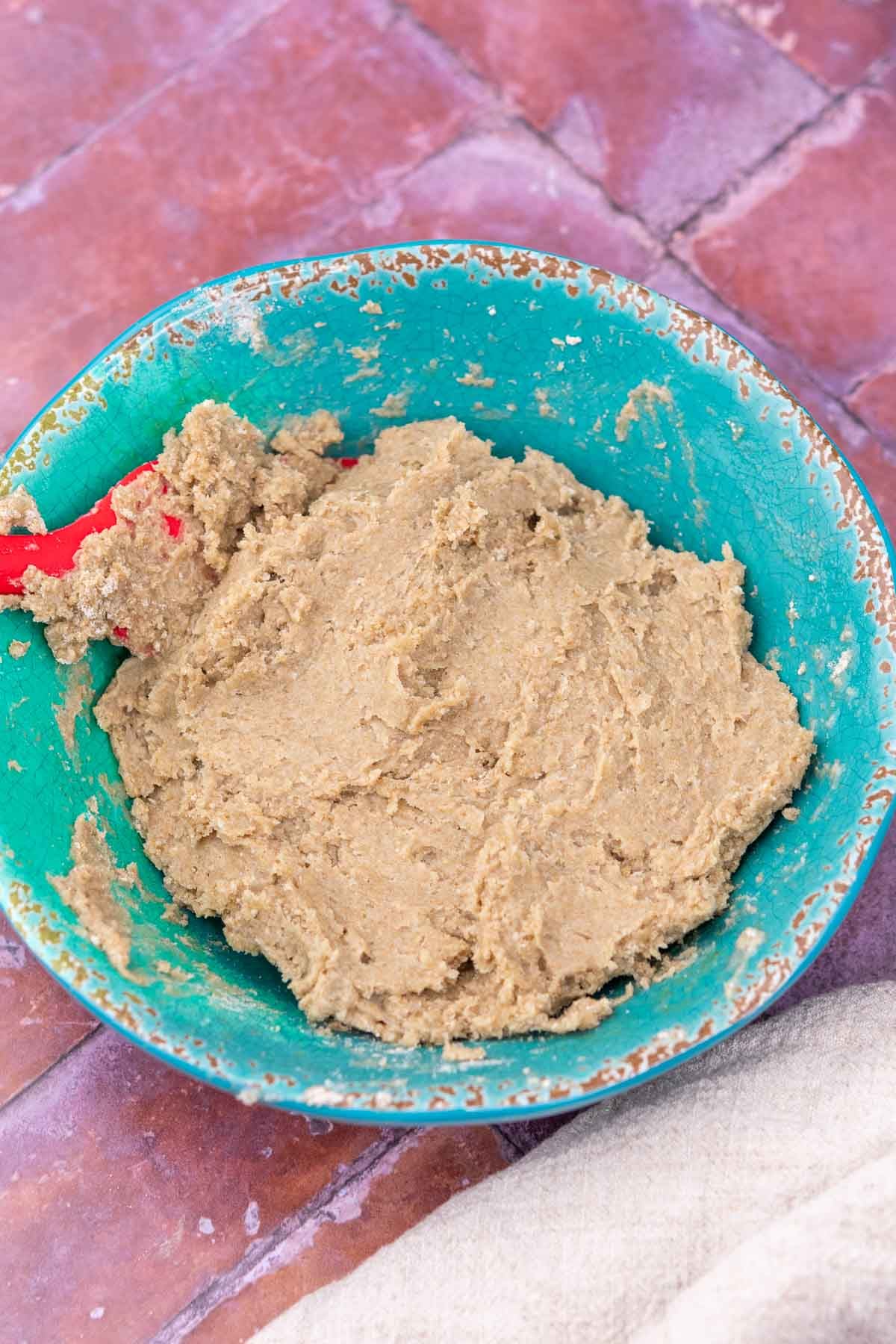 Bowl of mixed rye yudane or scalded rye flour with a spatula.