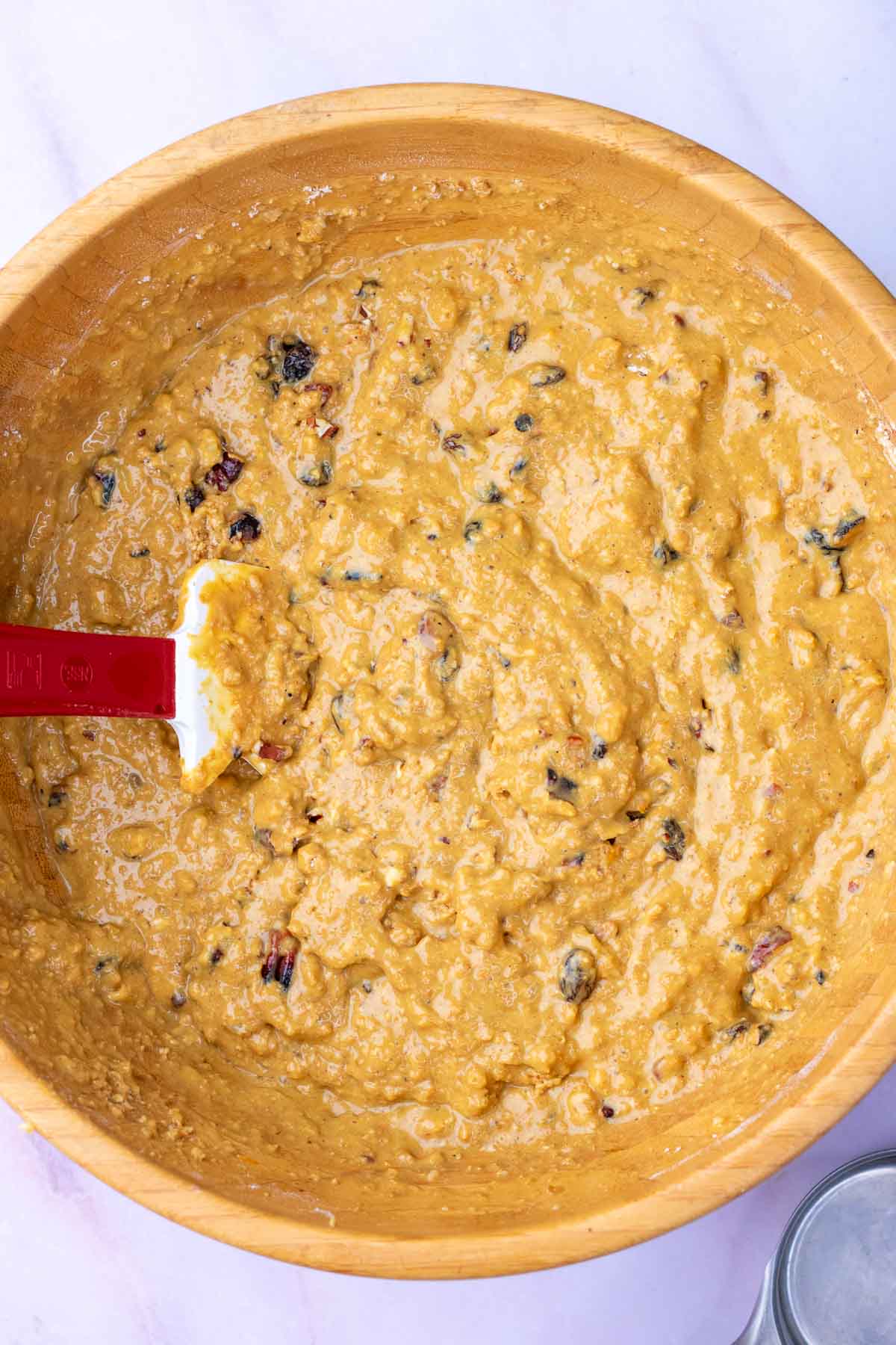 Mixed sourdough bran muffin batter in a bowl with a spatula.