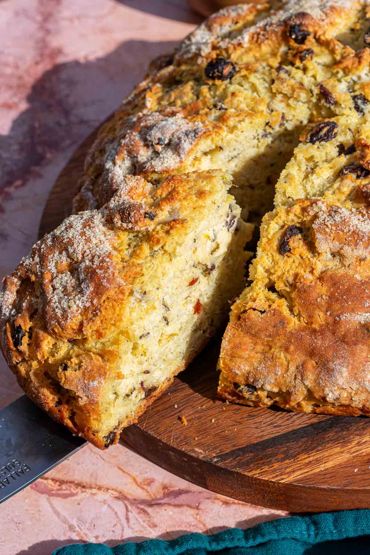Cutting a slice of Sourdough Irish soda bread on a cutting board.