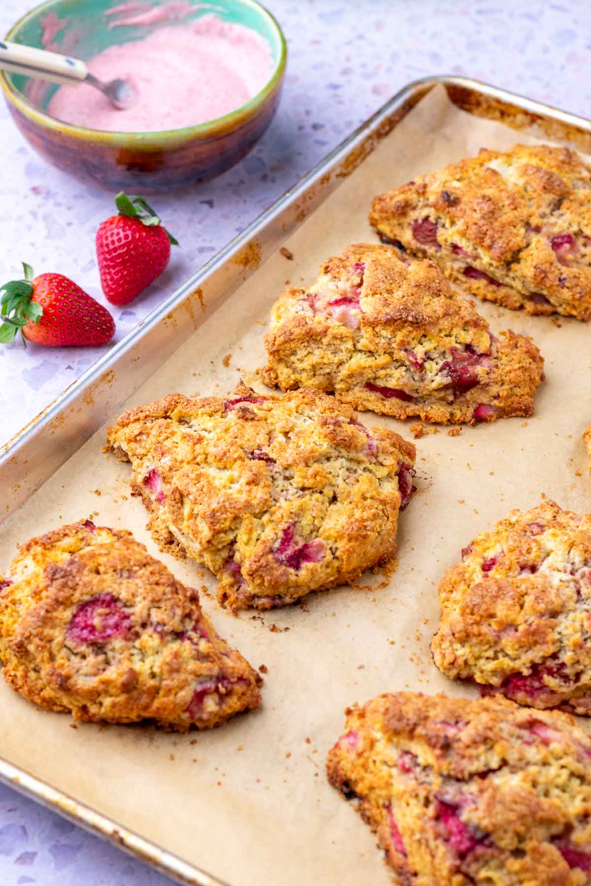 Baked sourdough strawberry scones on a baking sheet.