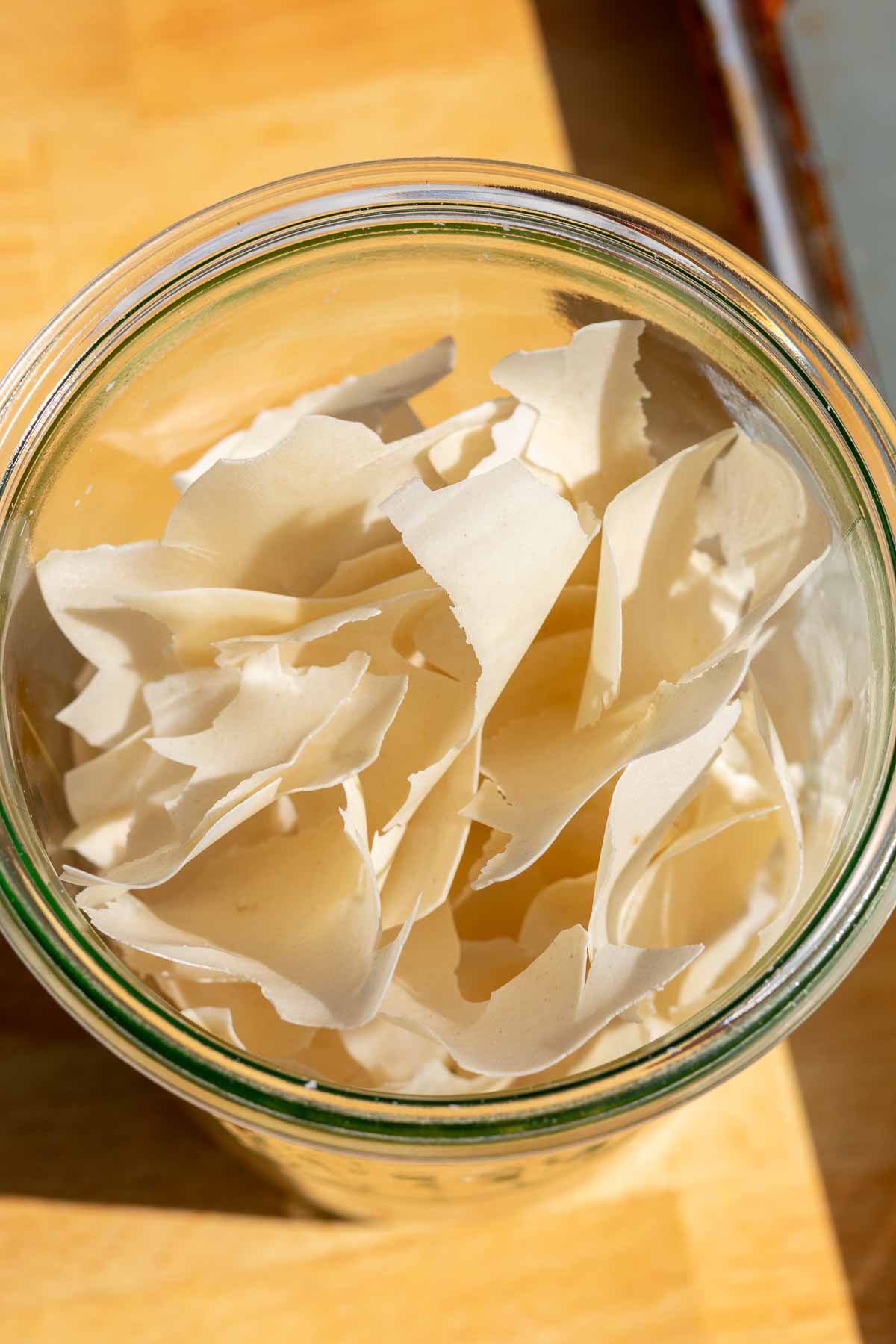 Flakes of dried sourdough starter in a glass jar.