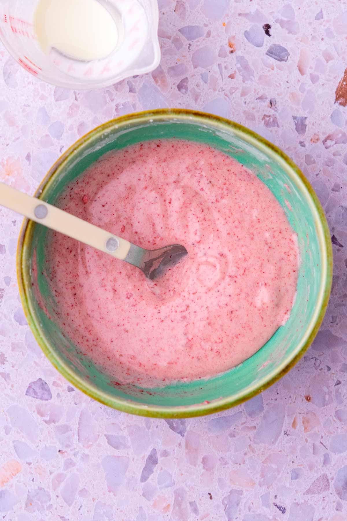 Mixed strawberry glaze in a bowl with a spoon.