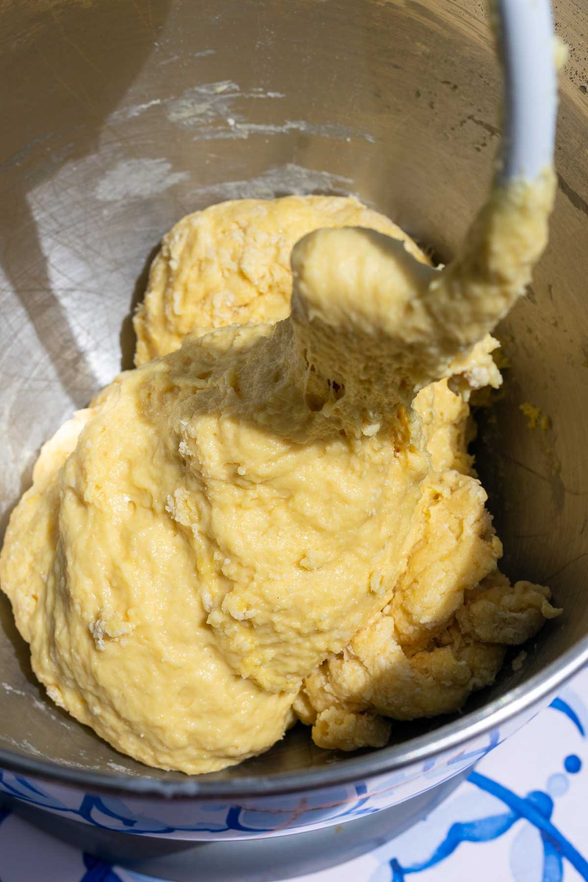 Mixing brioche dough in a stand mixer bowl with a dough hook.