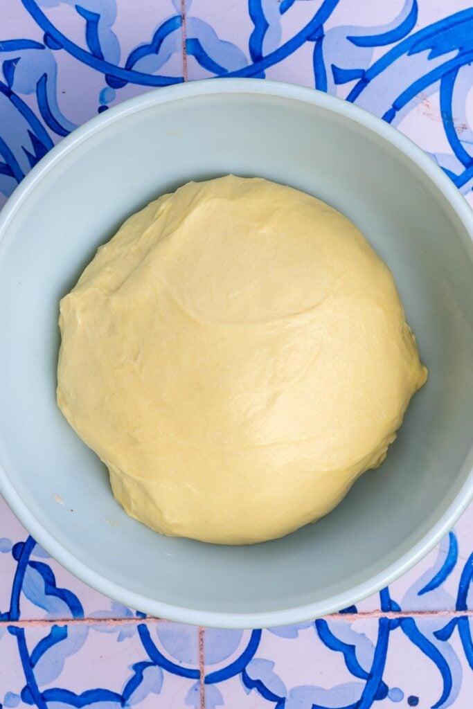 Brioche hamburger bun dough in bowl at the start of bulk fermentation.