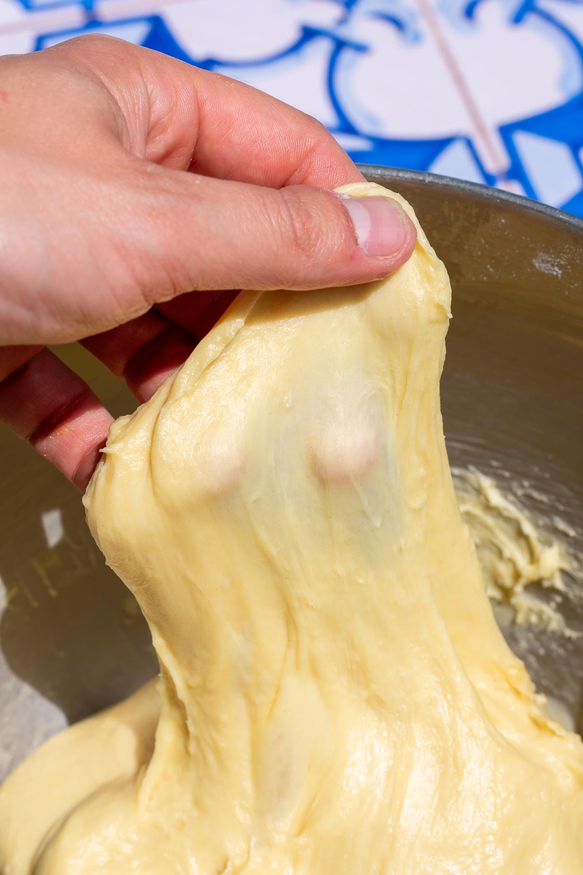 Brioche dough passing the windowpane test at the end of mixing.
