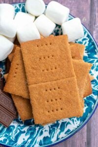 Sourdough graham crackers on an enamelware plate with chocolate and marshmallows for s'mores