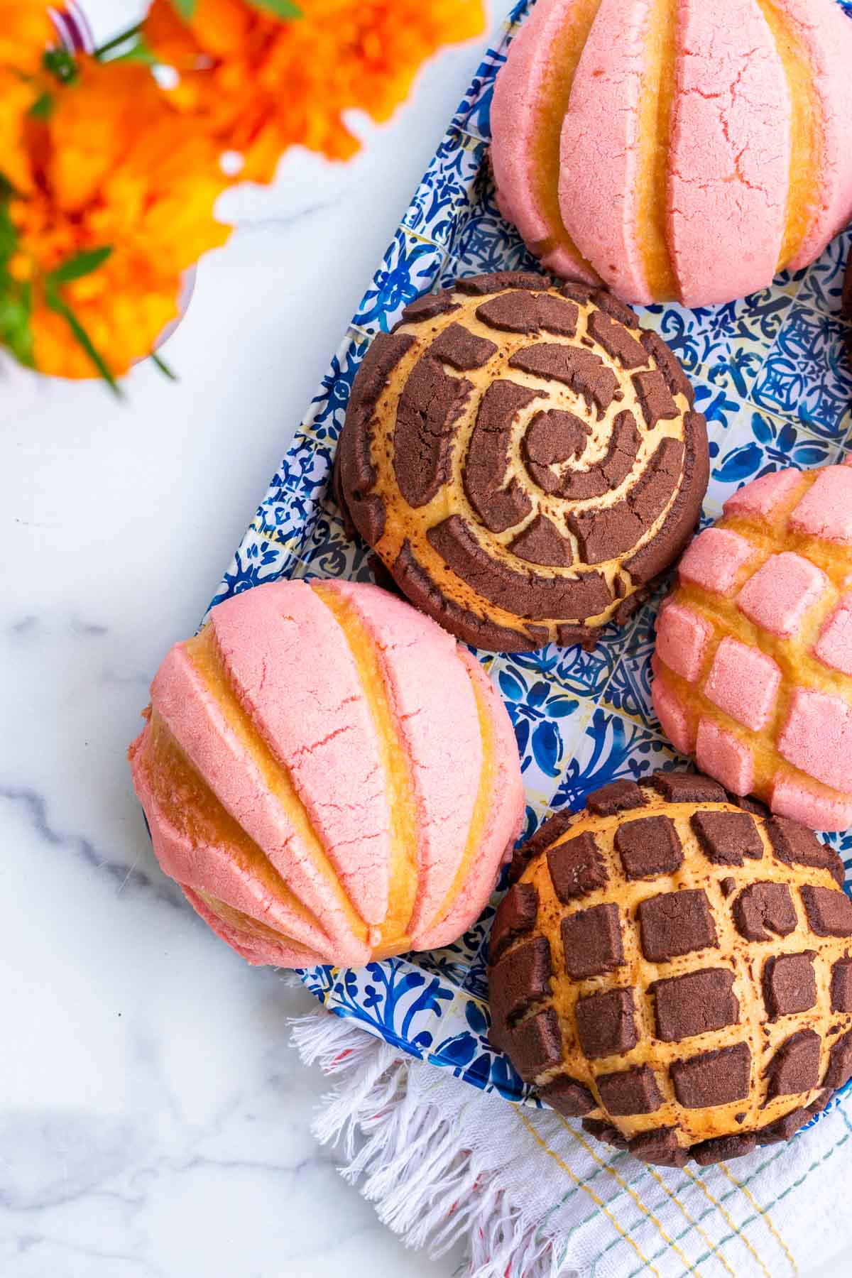 Chocolate and pink sourdough conchas on a platter.