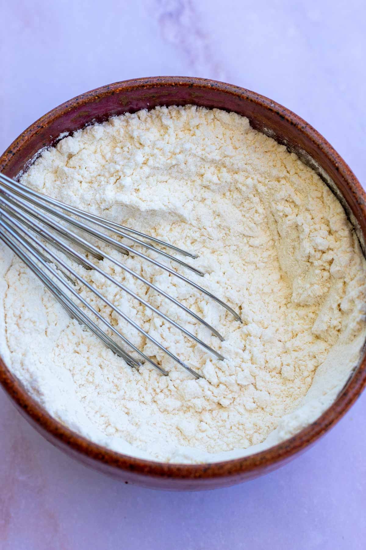 Bowl with a whisk of flour, salt, and baking powder, and baking soda.