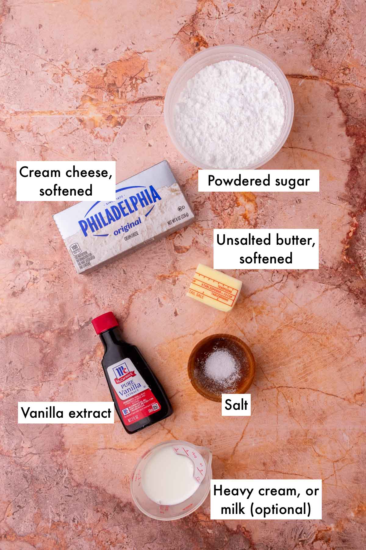 Labeled ingredients needed for cream cheese filling including cream cheese, powdered sugar, unsalted butter, vanilla extract, salt, and heavy cream.
