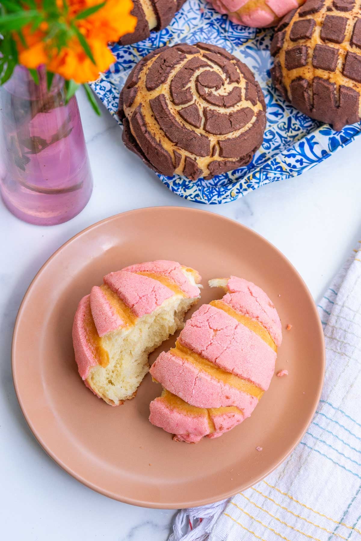 Sourdough concha torn in half on a plate.
