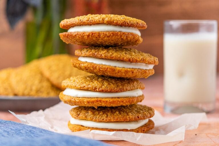 Stack of four sourdough oatmeal cream pies with a glass of milk in the background.