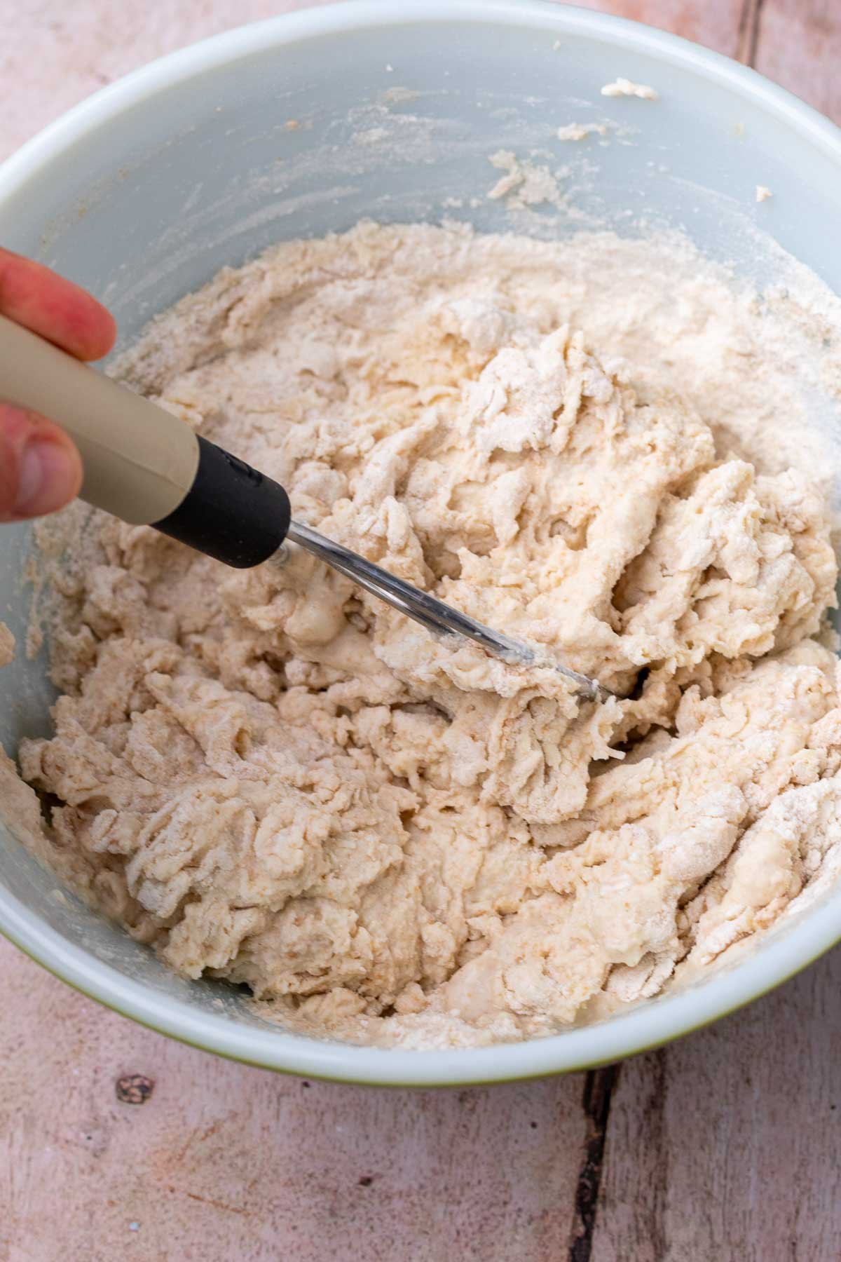 Mixing dough in bowl with a dough whisk for autolyse.