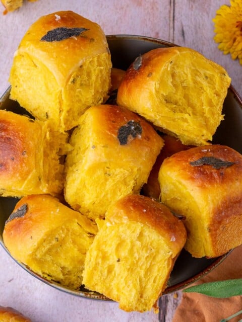 Bowl of sourdough sweet potato dinner rolls with sage.