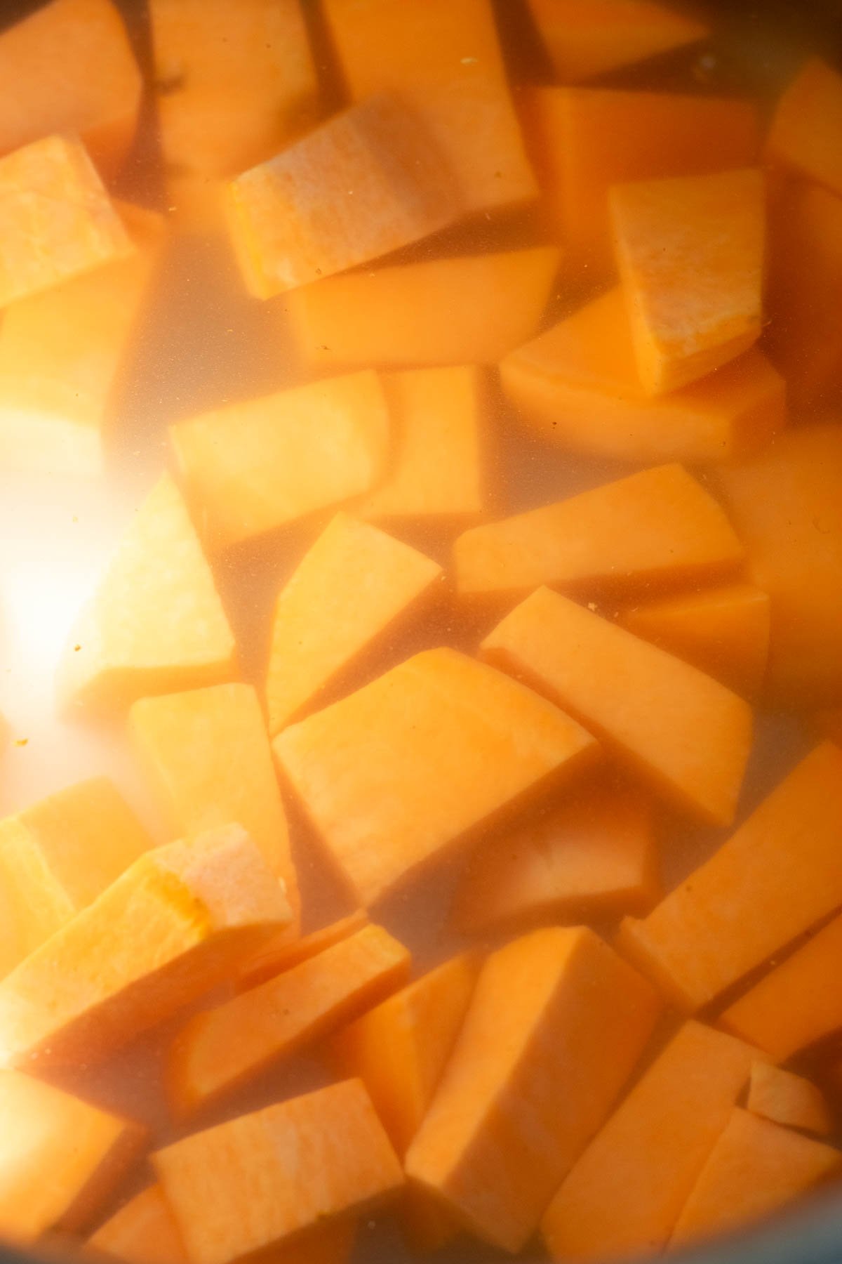 Chopped sweet potatoes in a pot with water.