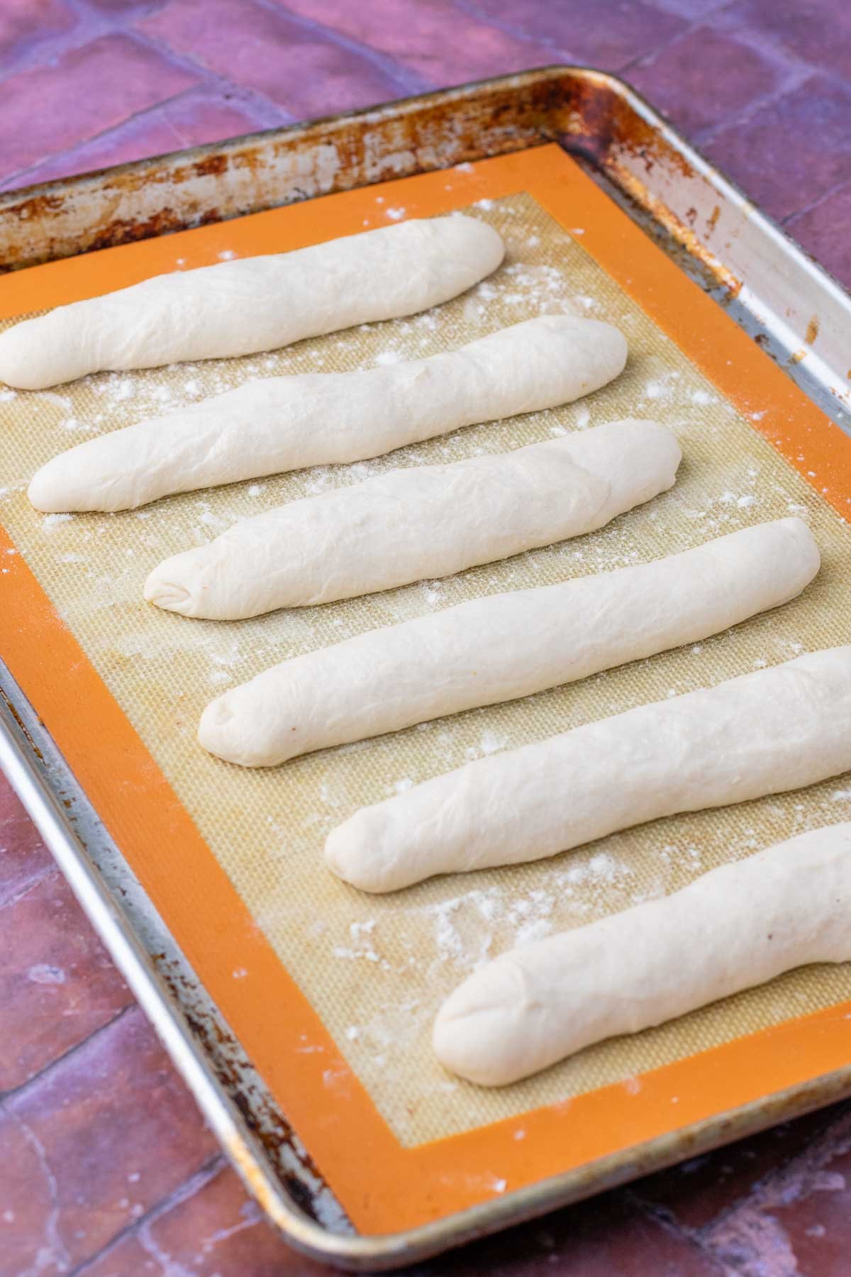 Sourdough breadsticks on baking sheet at the end of final proof.