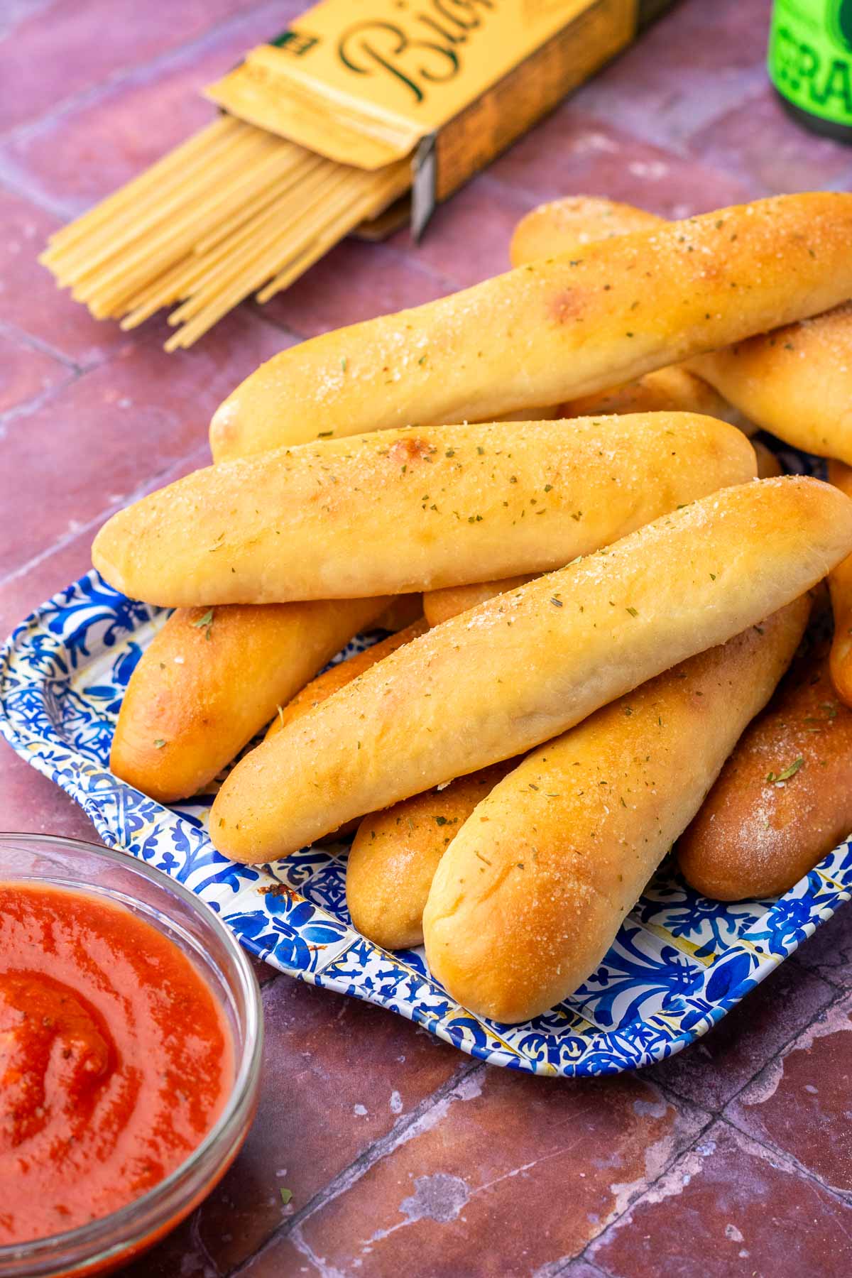 Sourdough breadsticks on a platter with marinara sauce.