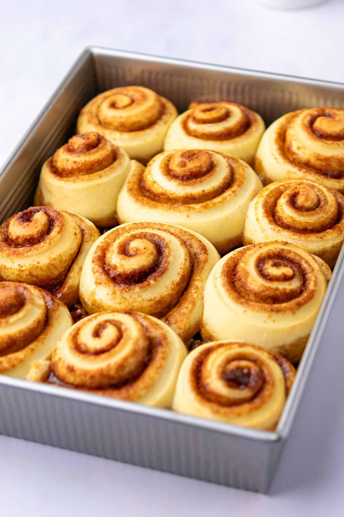 Baked sourdough maple pecan sticky buns in baking dish.
