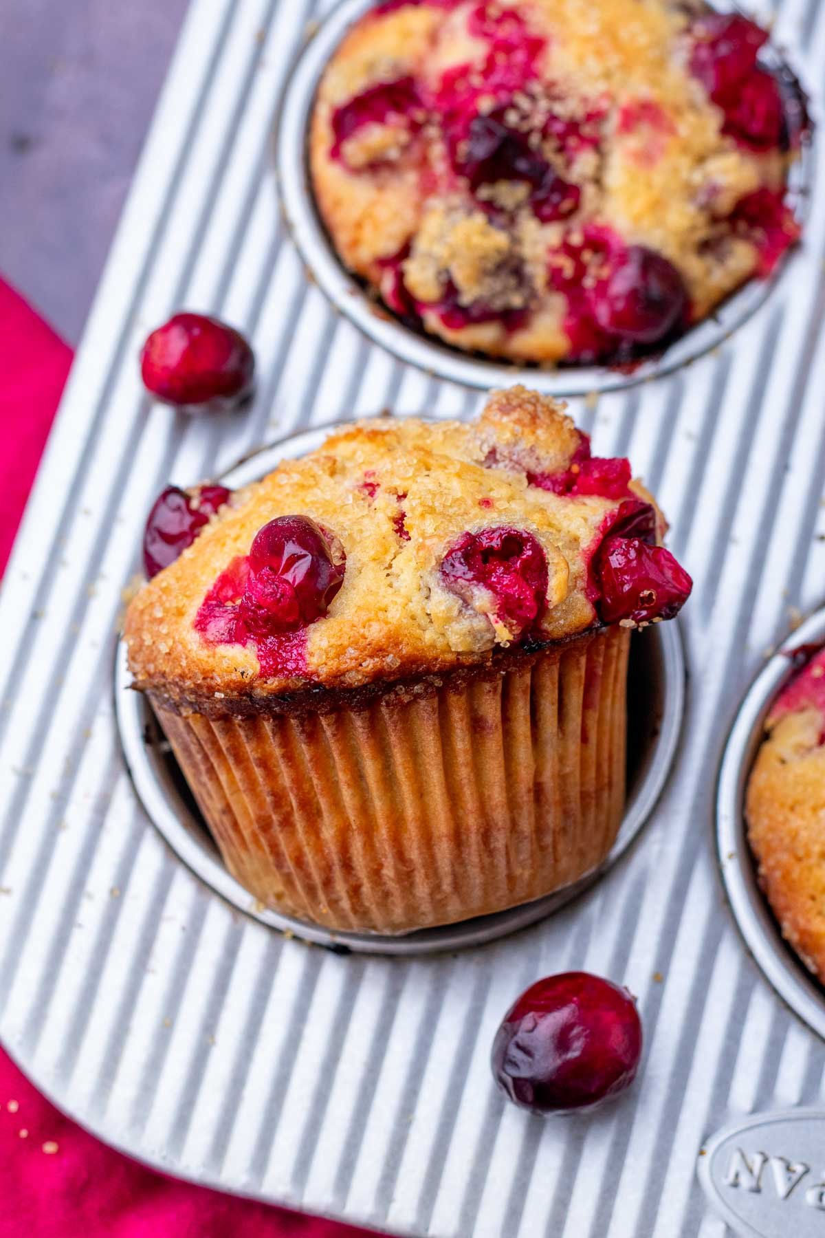 Baked sourdough cranberry muffin in a muffin pan.