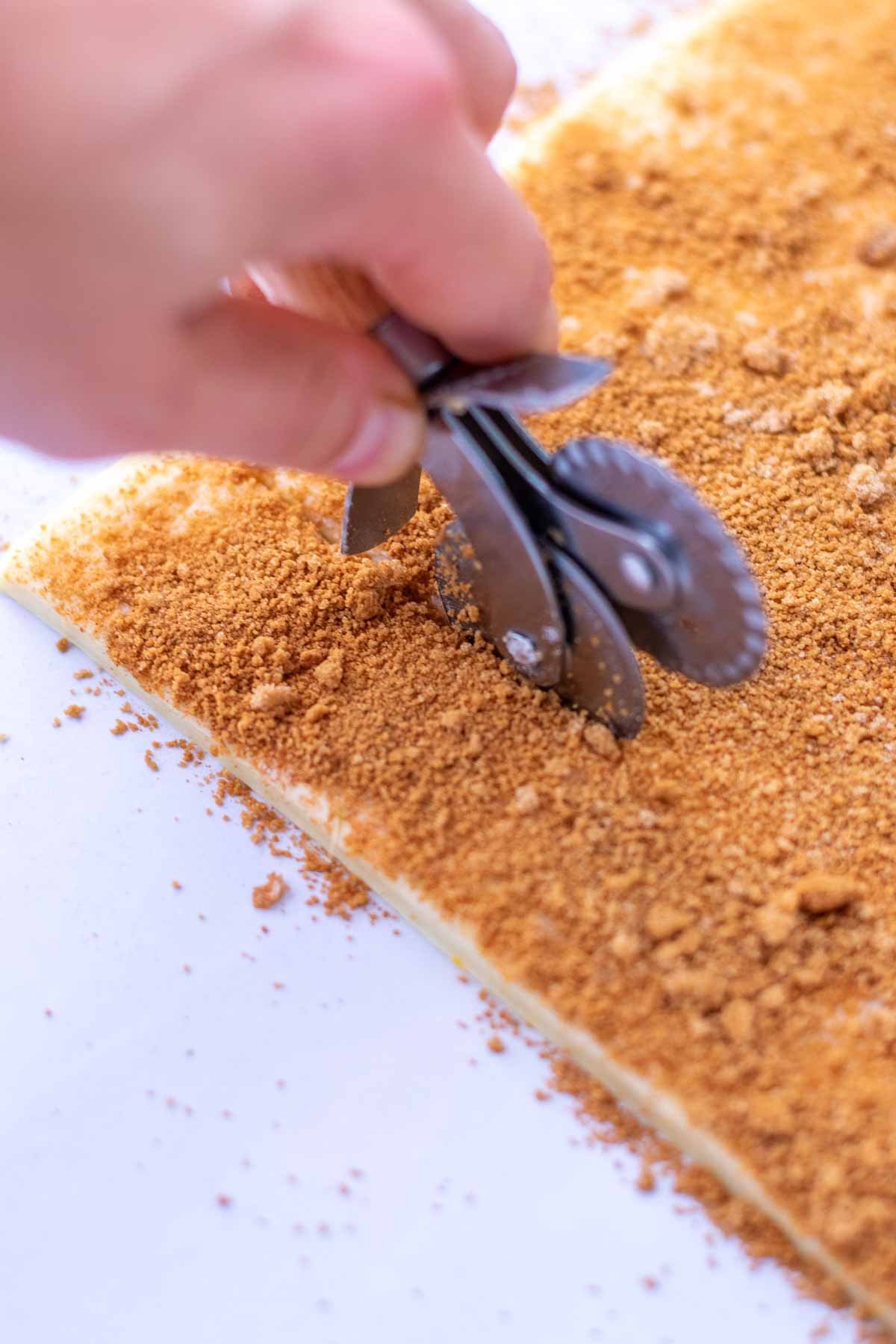 Cutting Sourdough sticky buns with a pastry wheel.