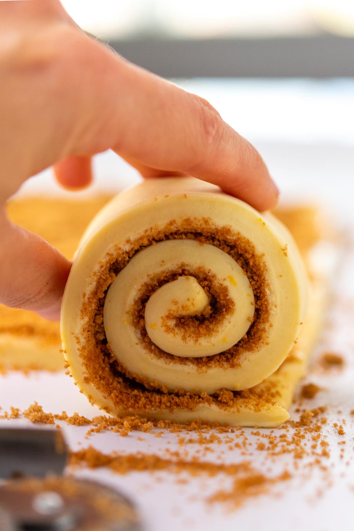 Hand rolling up a sourdough sticky bun.