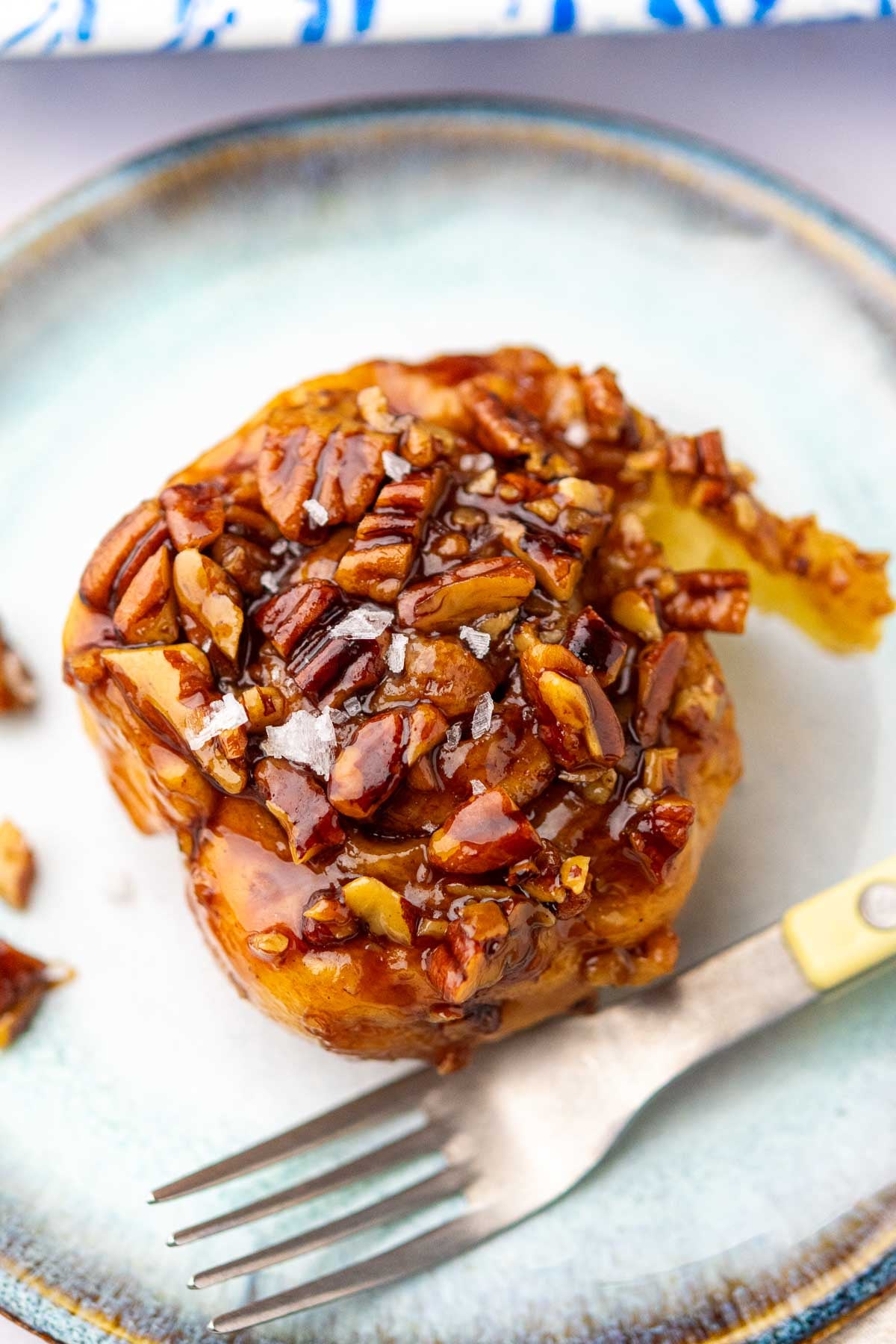 Close up of a Sourdough maple pecan sticky bun with flaky salt.