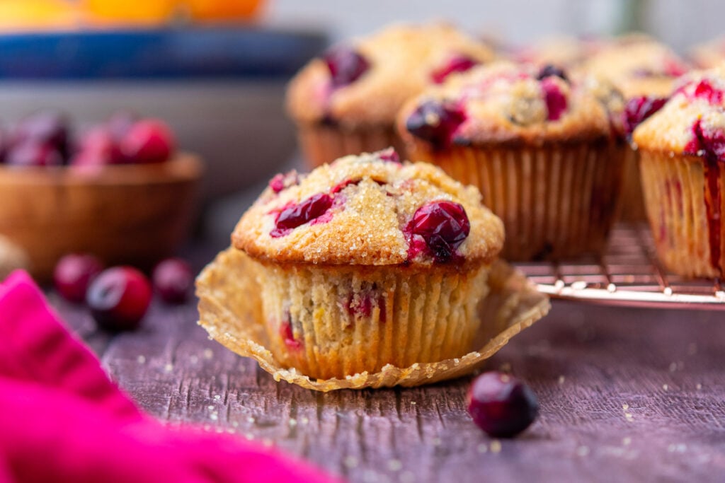 Sourdough cranberry muffins with oranges in the background.