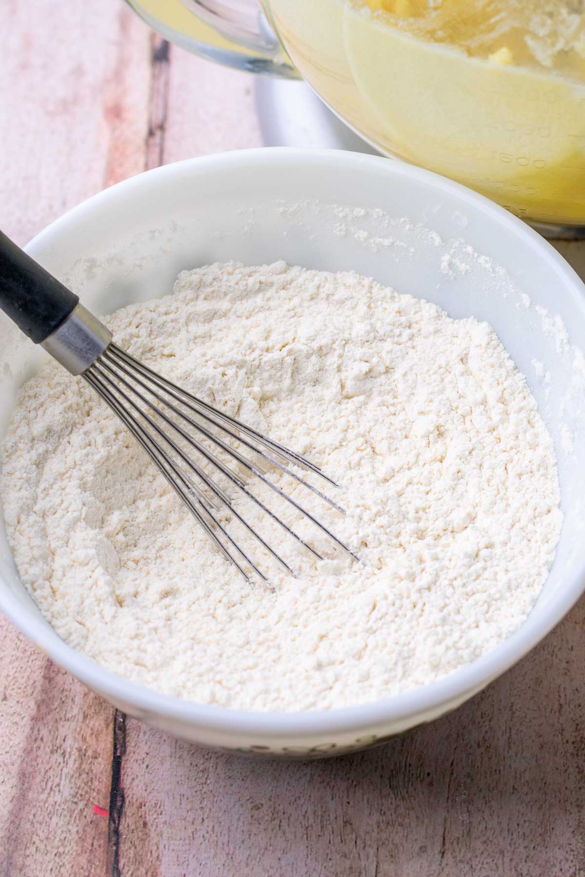 Bowl of dry ingredients for sourdough sugar cookies with a whisk.