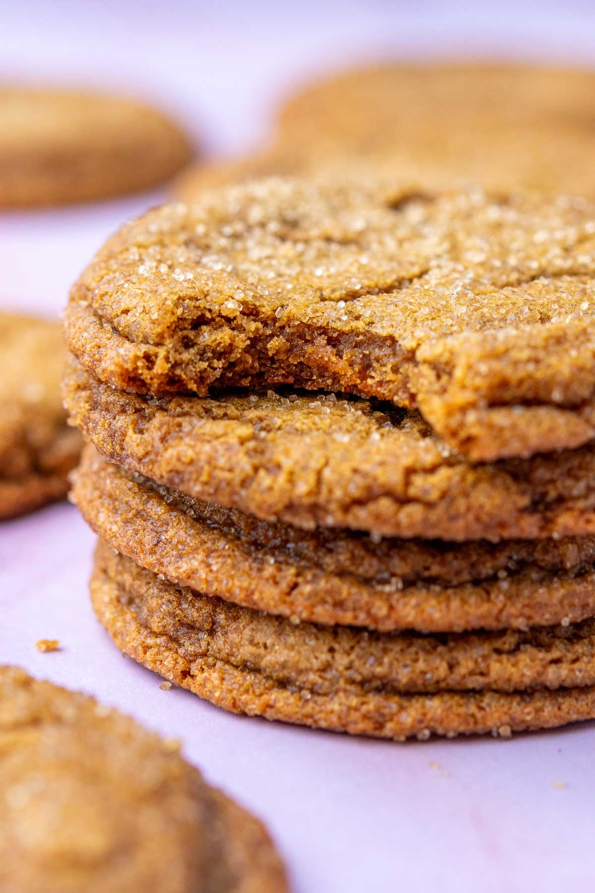 Stack of Sourdough ginger molasses cookies with bite taken out of top one.
